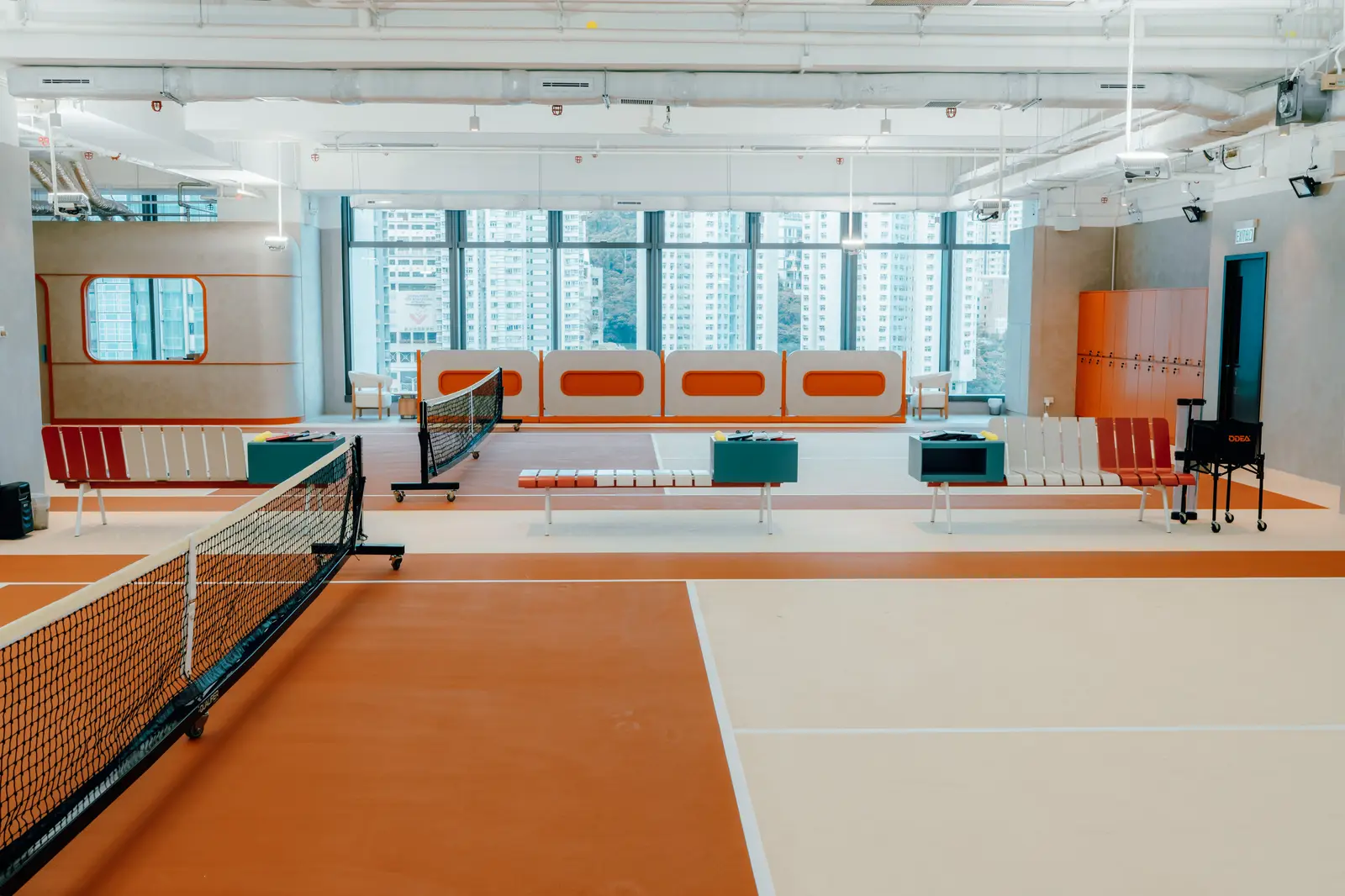 The Asia Aces clubhouse, with café tables, viewing pod and court beyond
